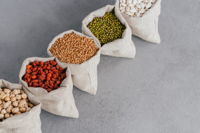 Assorted gluten free grains in linen cloth bags on grey background